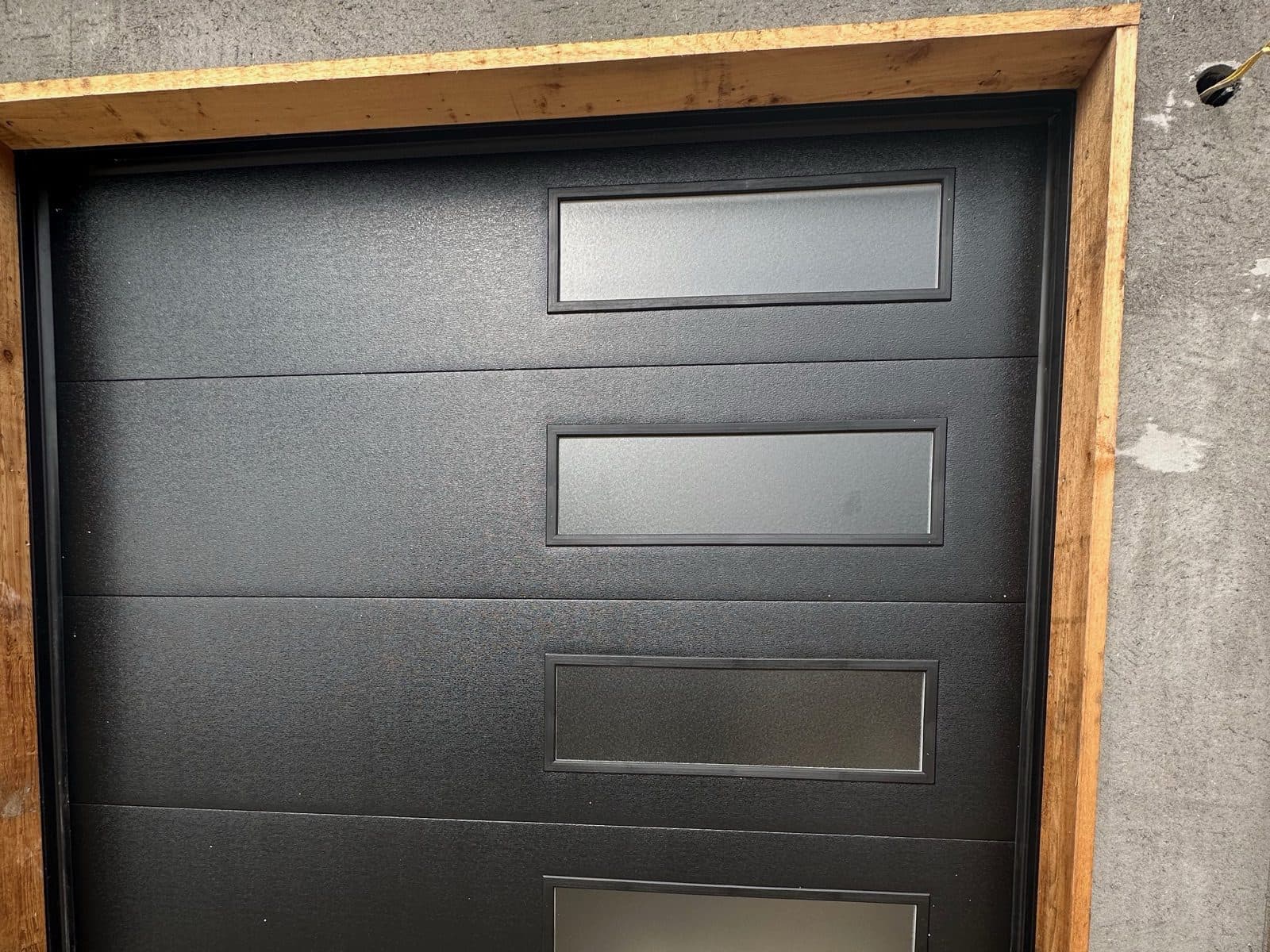 Black flush contemporary garage door with four frosted windows