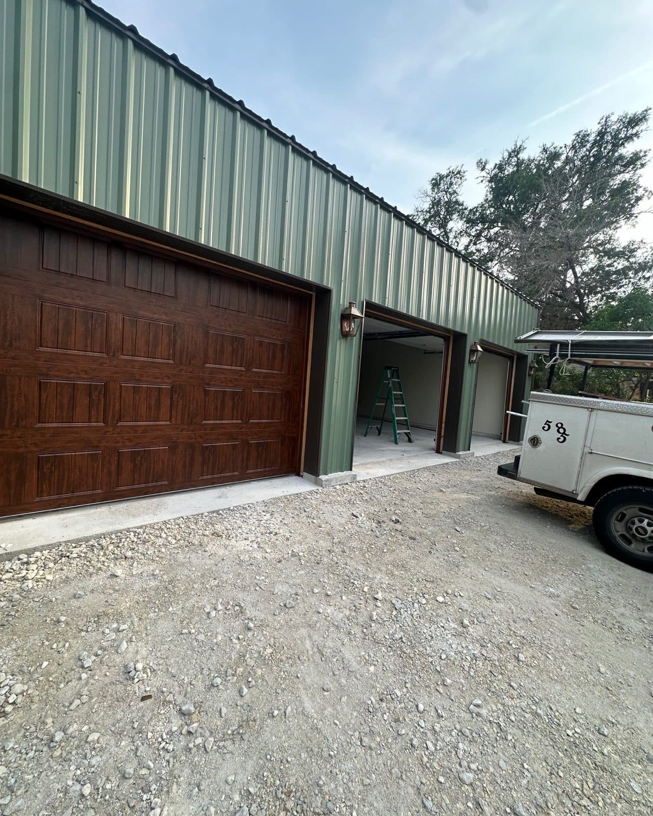 A SanTex installation in progress: a finished walnut door beside an open bay with the work truck