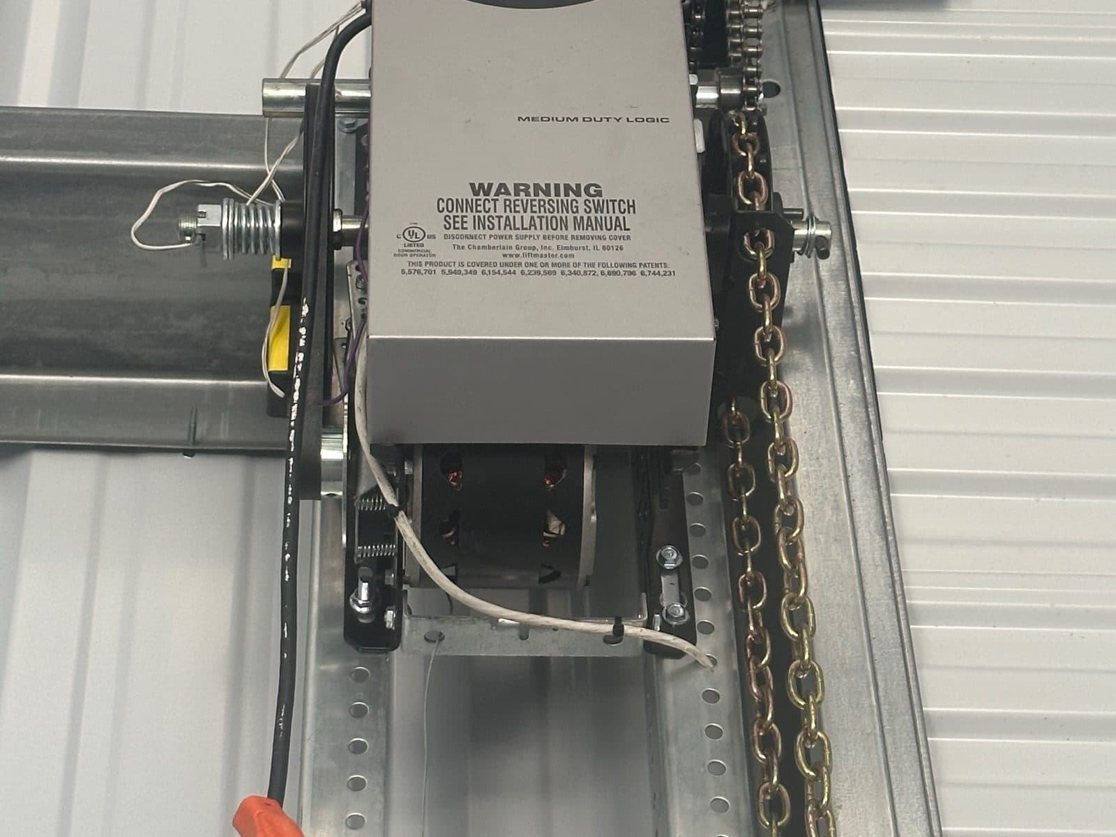 Garage door opener and chain hoist on a white wall